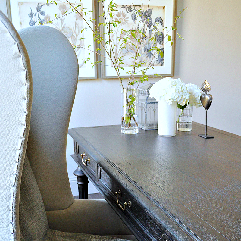 Home Office with Black Desk with Gold Pulls and Gray Wingback Chair