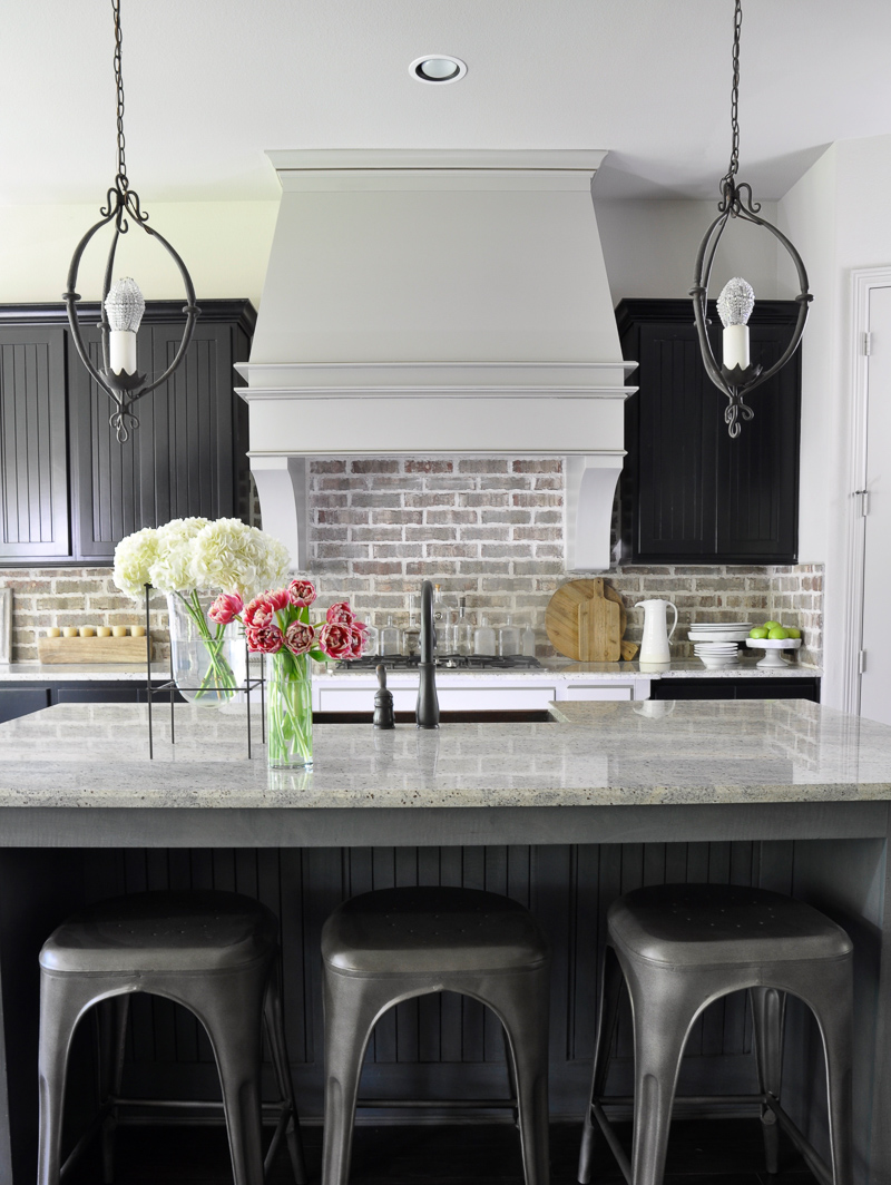 Kitchen with Brick Backsplash Large Venthood and Industrial Stools