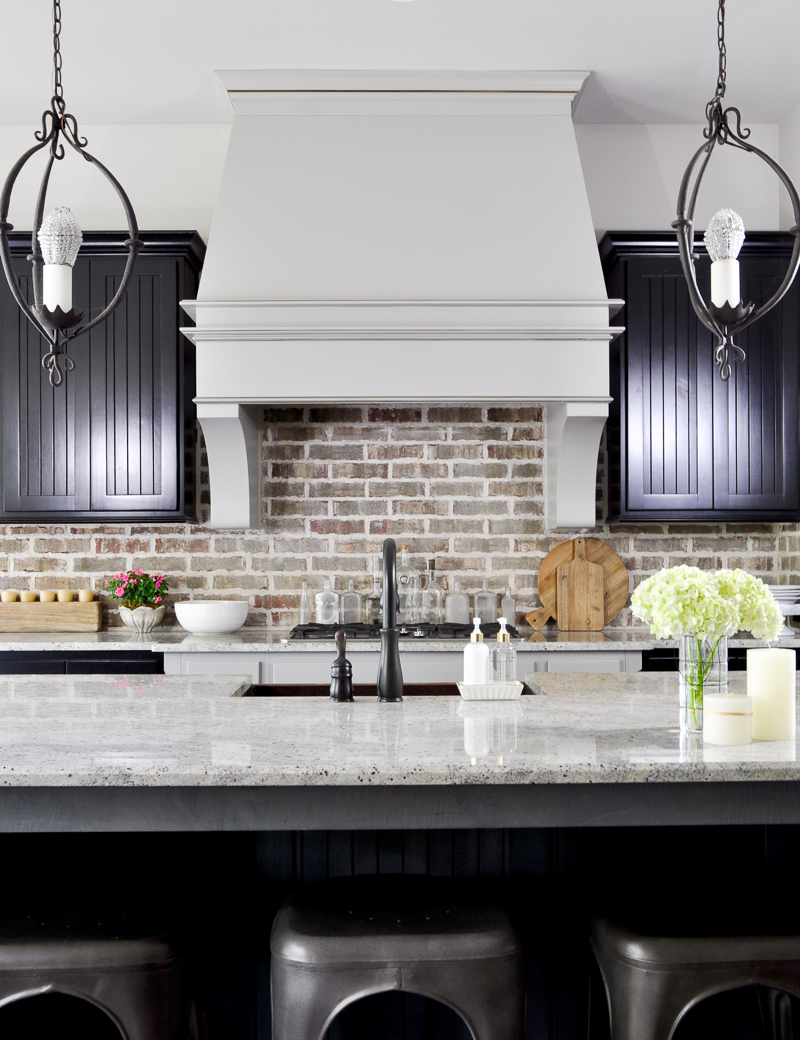 Kitchen with Statement Vent Hood and Black Cabinets decorated for summer