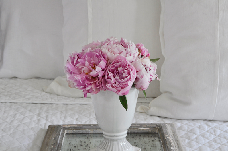 bedroom with pink peonies on beautiul tray on white linens