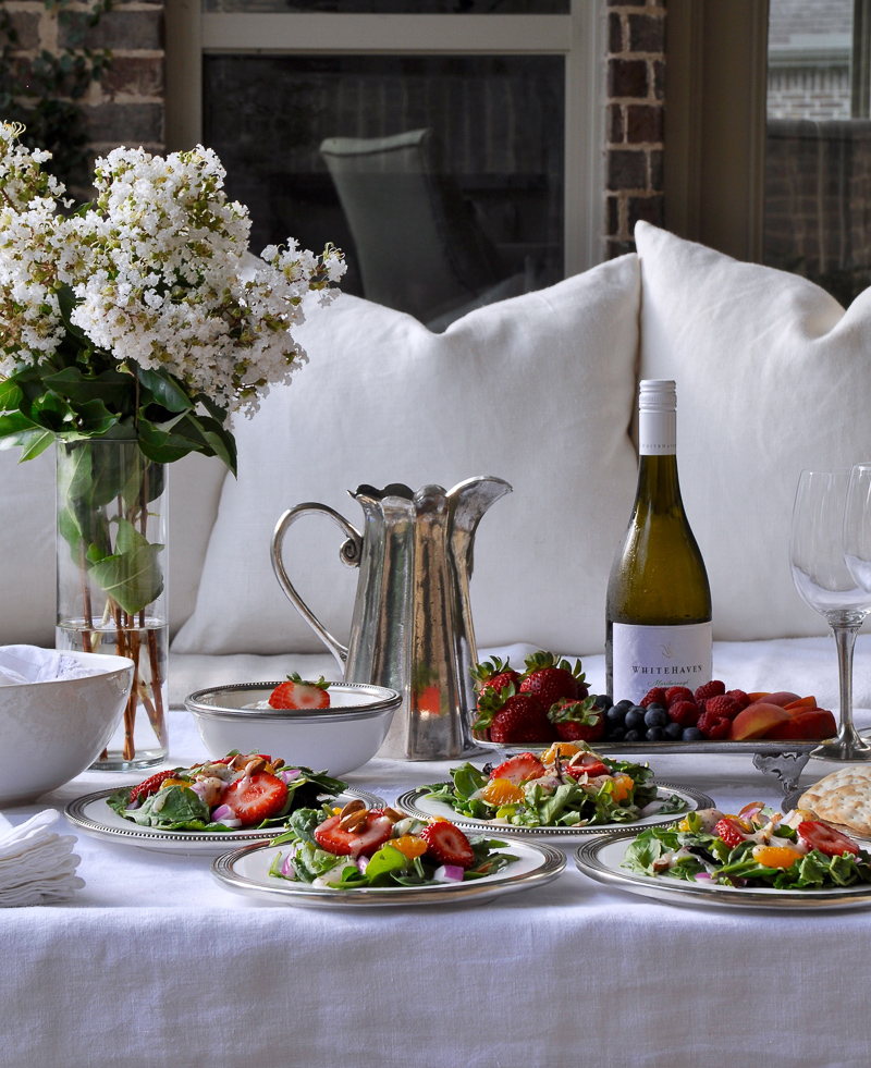 Outdoor patio dinner with flowers white dinnerware and pewter and beautiful salads and fruit-10