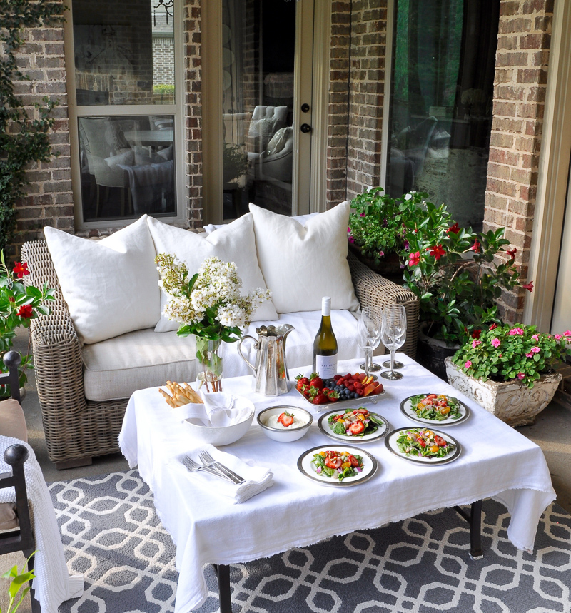 Outdoor patio dinner with flowers white dinnerware and pewter and beautiful salads and fruit-21