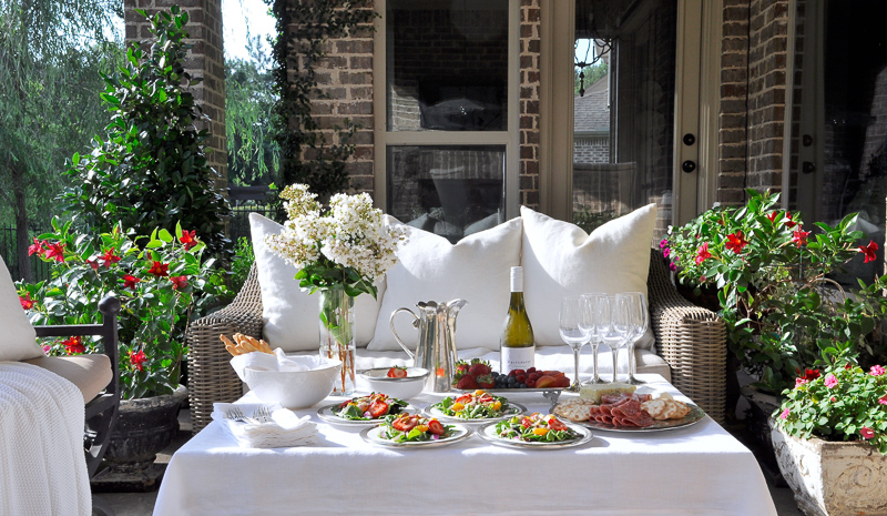 Outdoor patio dinner with flowers white dinnerware and pewter and beautiful salads and fruit-7