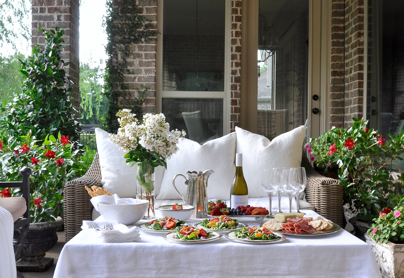 Outdoor patio dinner with flowers white dinnerware and pewter and beautiful salads and fruit-9