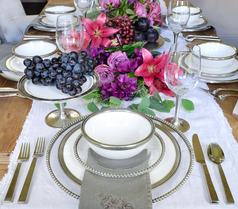 beautiful dining room set for a dinner party with ceramic and pewter dinnerware by arte italica and floral garland_