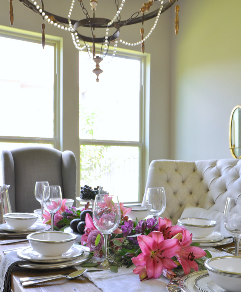 beautiful dining room with white ceramic and pewter dinnerware and bright flowers in centerpiece by arte italica_