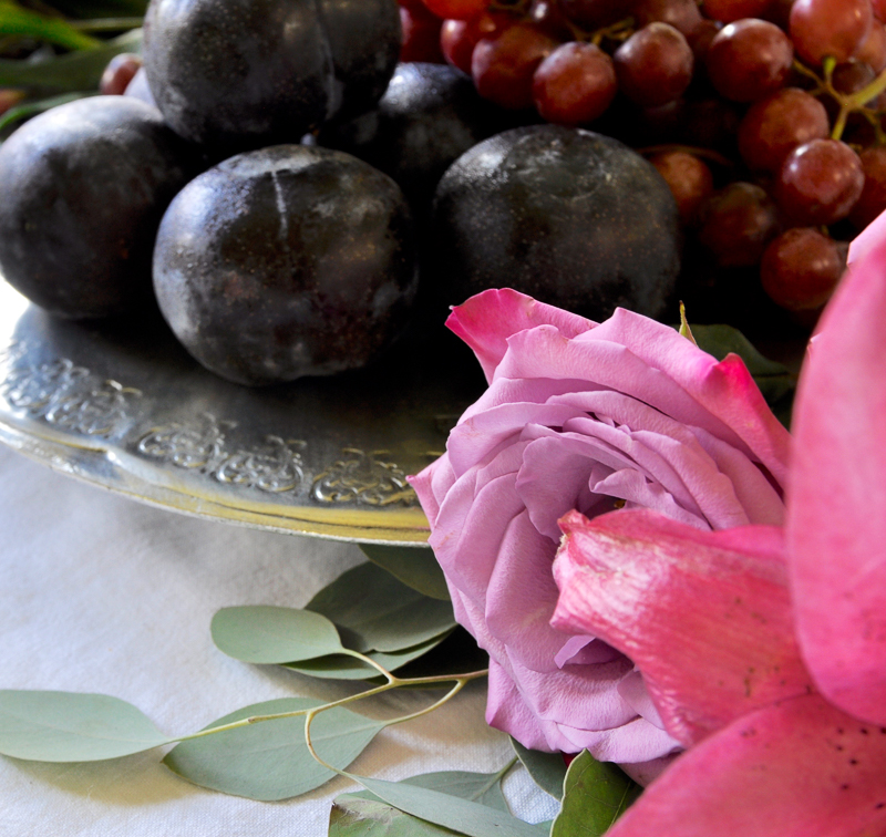 flowers and fruit add beauty to a centerpiece on a pewter serve=ing dish by arte italica