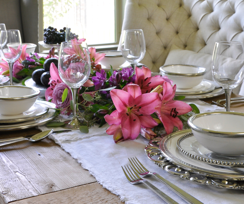 tablescape with fruit and flowers and white ceramic and pewter dishes by arte italica_