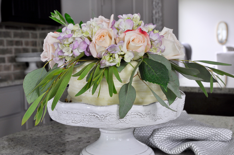 gorgeous decorated grocery store cake on white anthropologie cake stand_