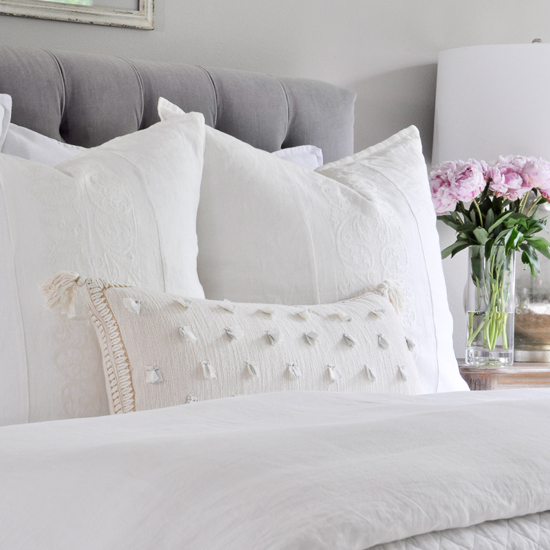 white bedding with colorful pillows