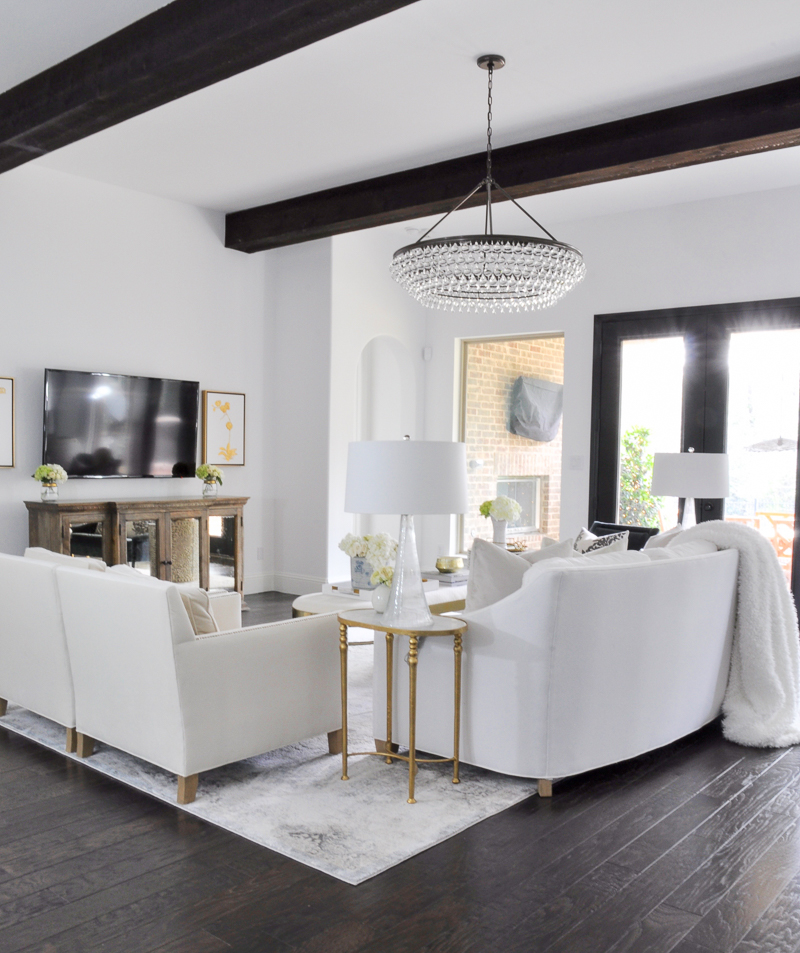 elegant white living room with gold accents and gorgeous chandelier