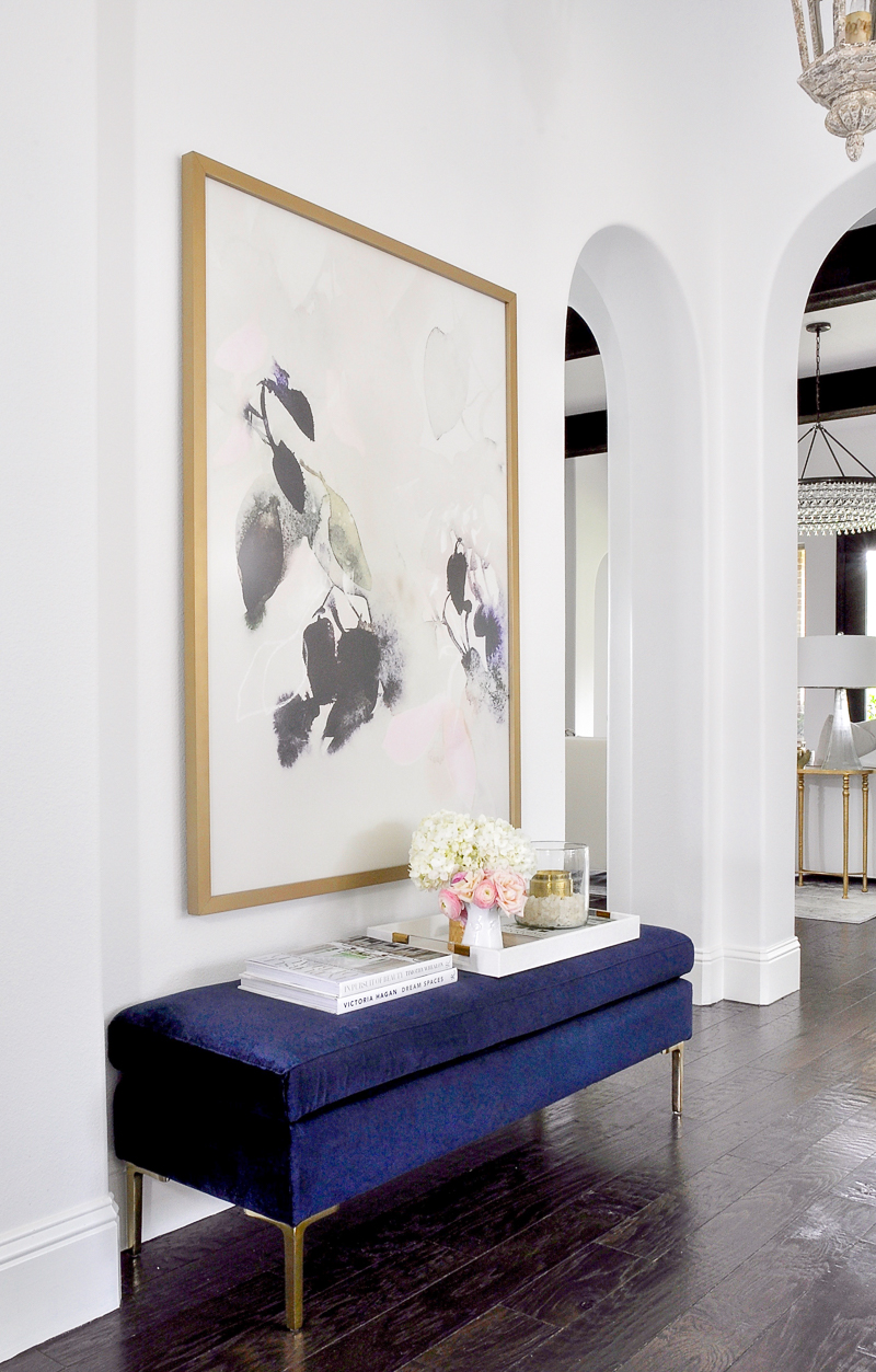 decorated home entry with blue velvet bench and beautiful large artwork