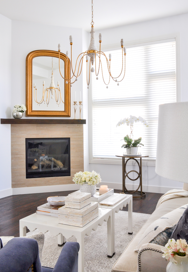 elegant arched gold mirror and chandelier in white living room