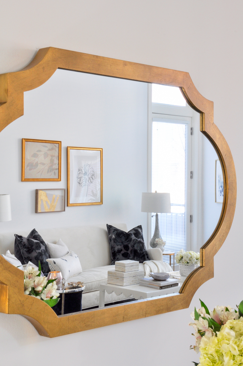 elegant gold mirror with beautiful white living room in reflection