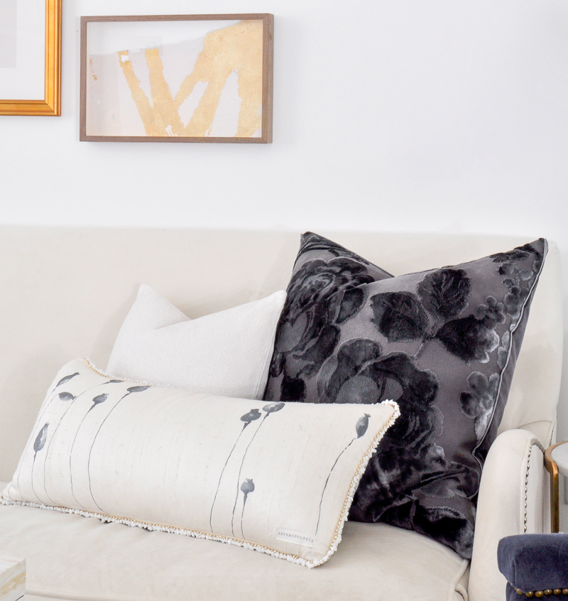 navy and white pillows on white sofa