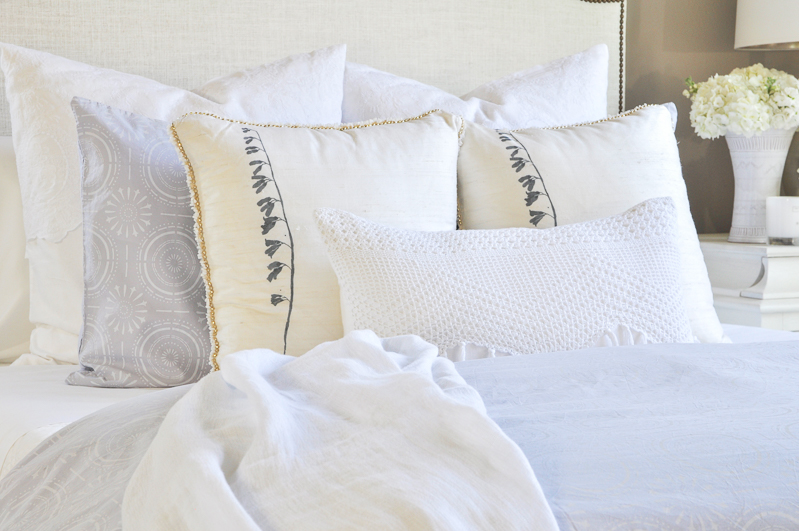 beautiful layered bed with white bedding