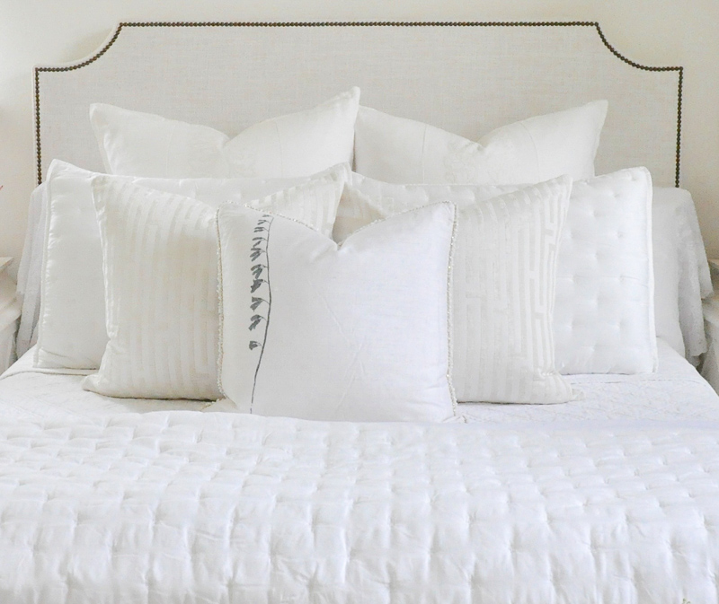 Dreamy bedroom overstuffed white pillows 