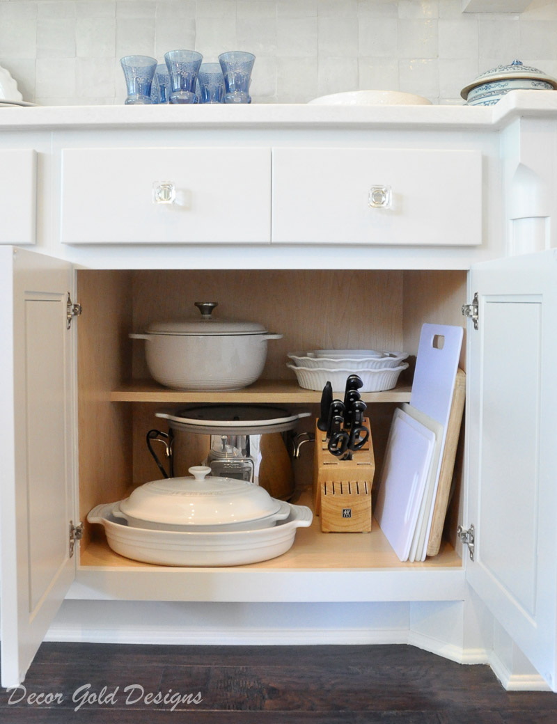 Kitchen organization project lower cabinet containing stoneware crockpot knife block cutting boards